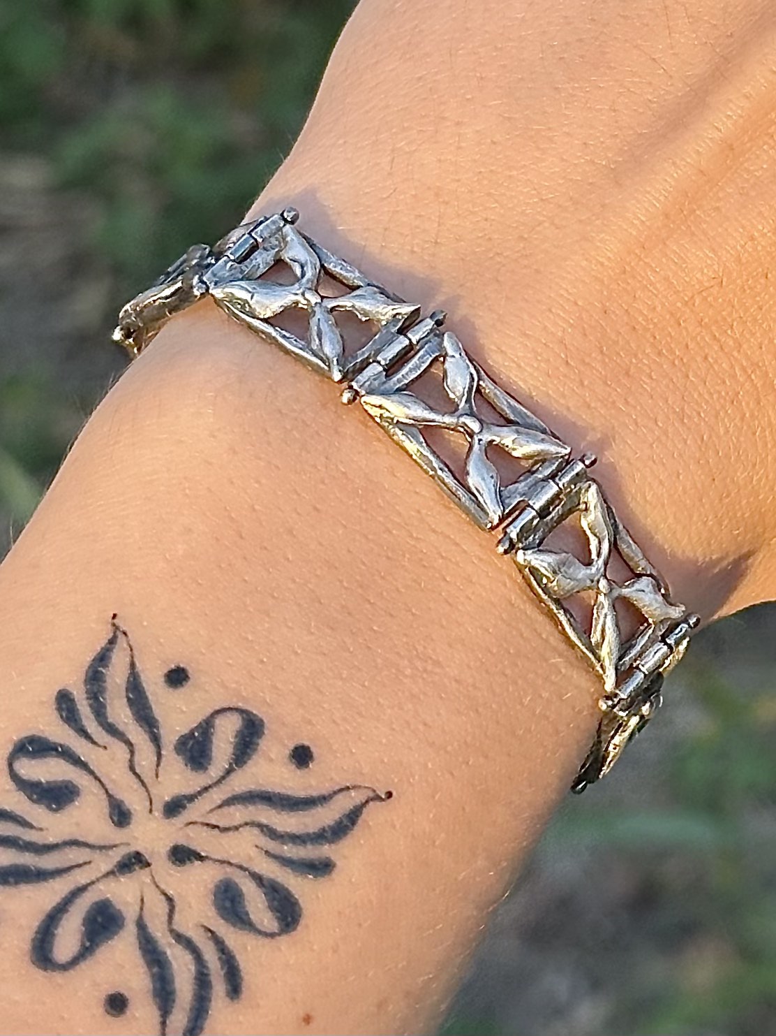 Sterling silver bracelet with square abstract links on a wrist with an abstract tattoo
